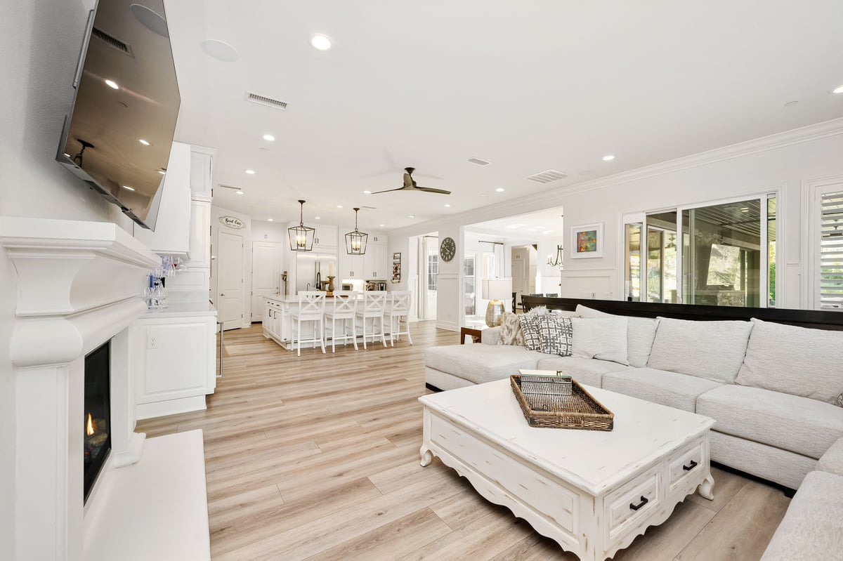 Bright elegant open-concept living space with cozy sofa and stylish furnishings in a luxury renovated home