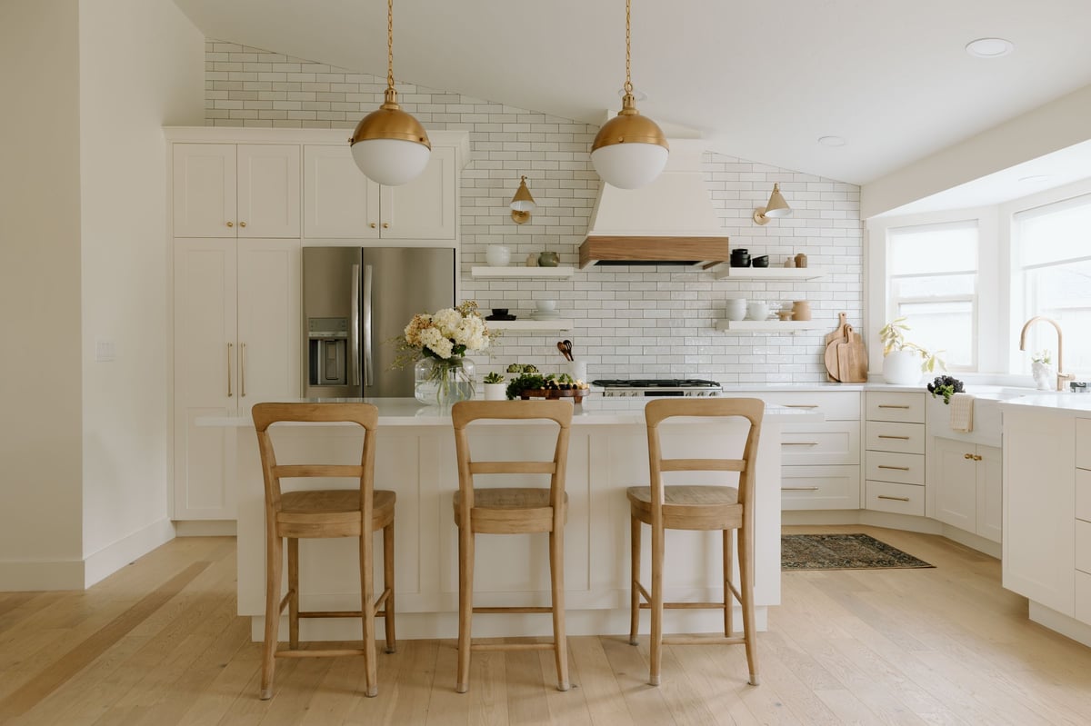Modern farmhouse kitchen with airy bright interior white cabinets marble countertops island